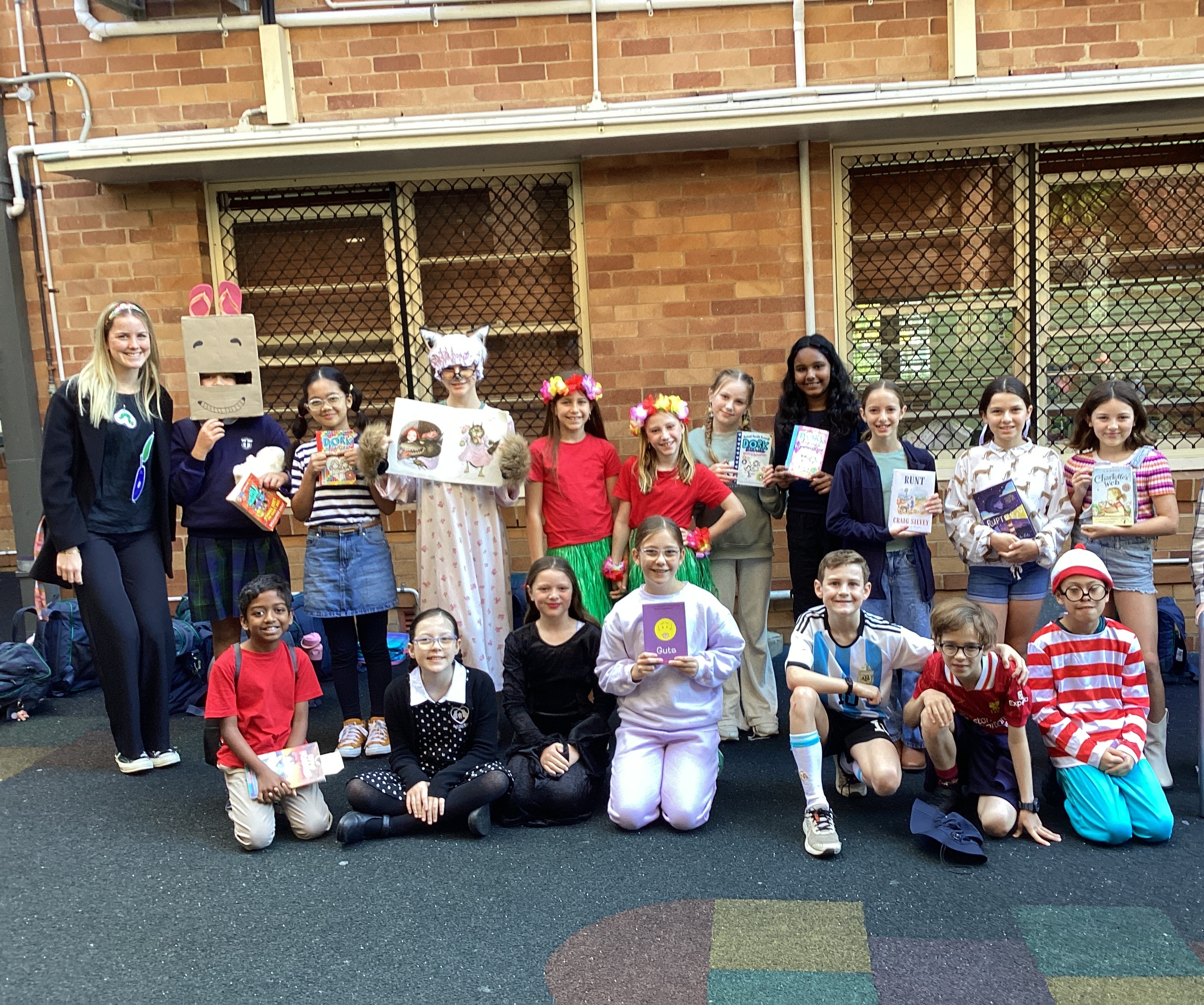 Students holding books in costume during a school literacy event.