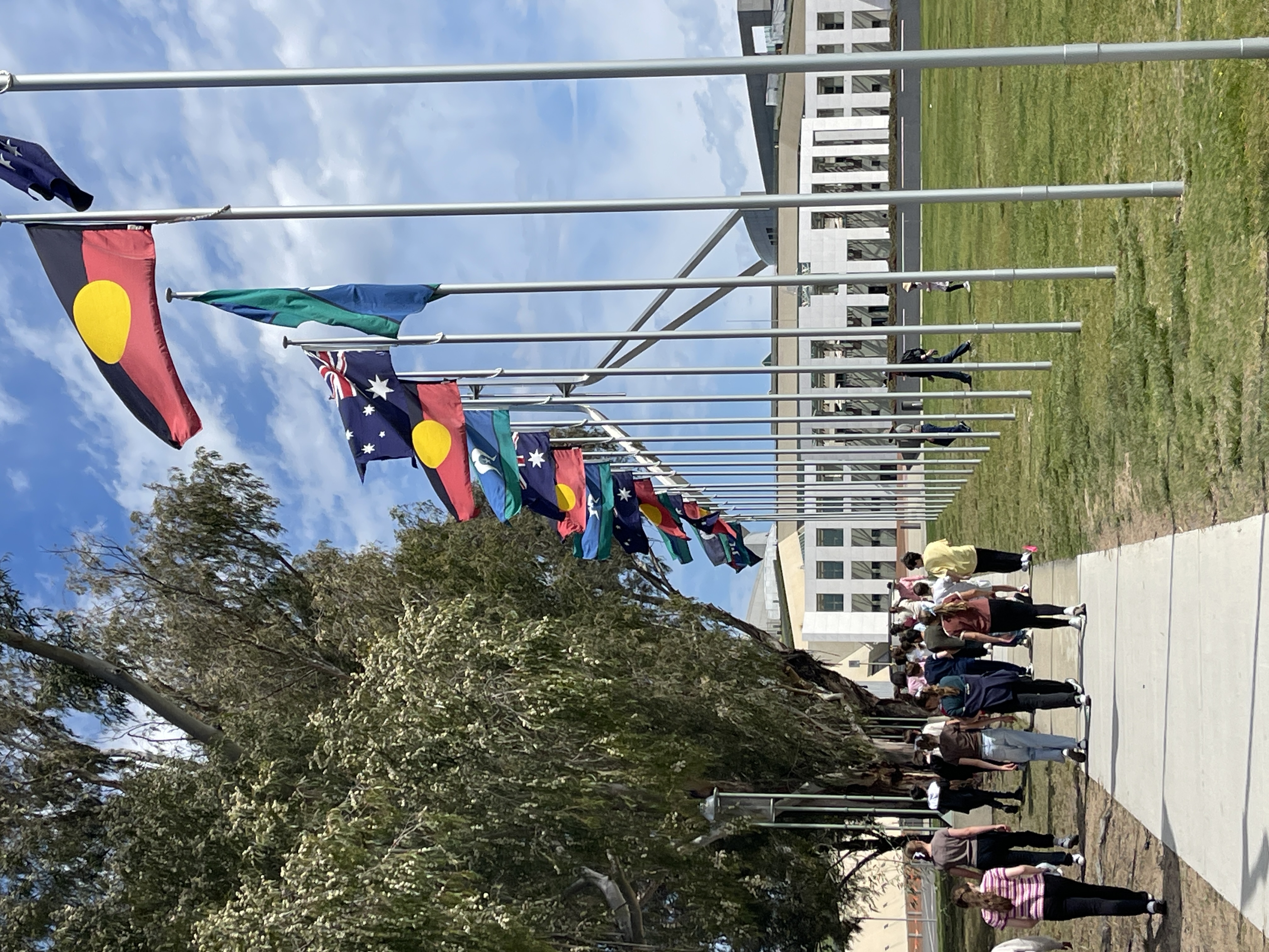 Pathway lined with Aboriginal and Australian flags near Parliament House.