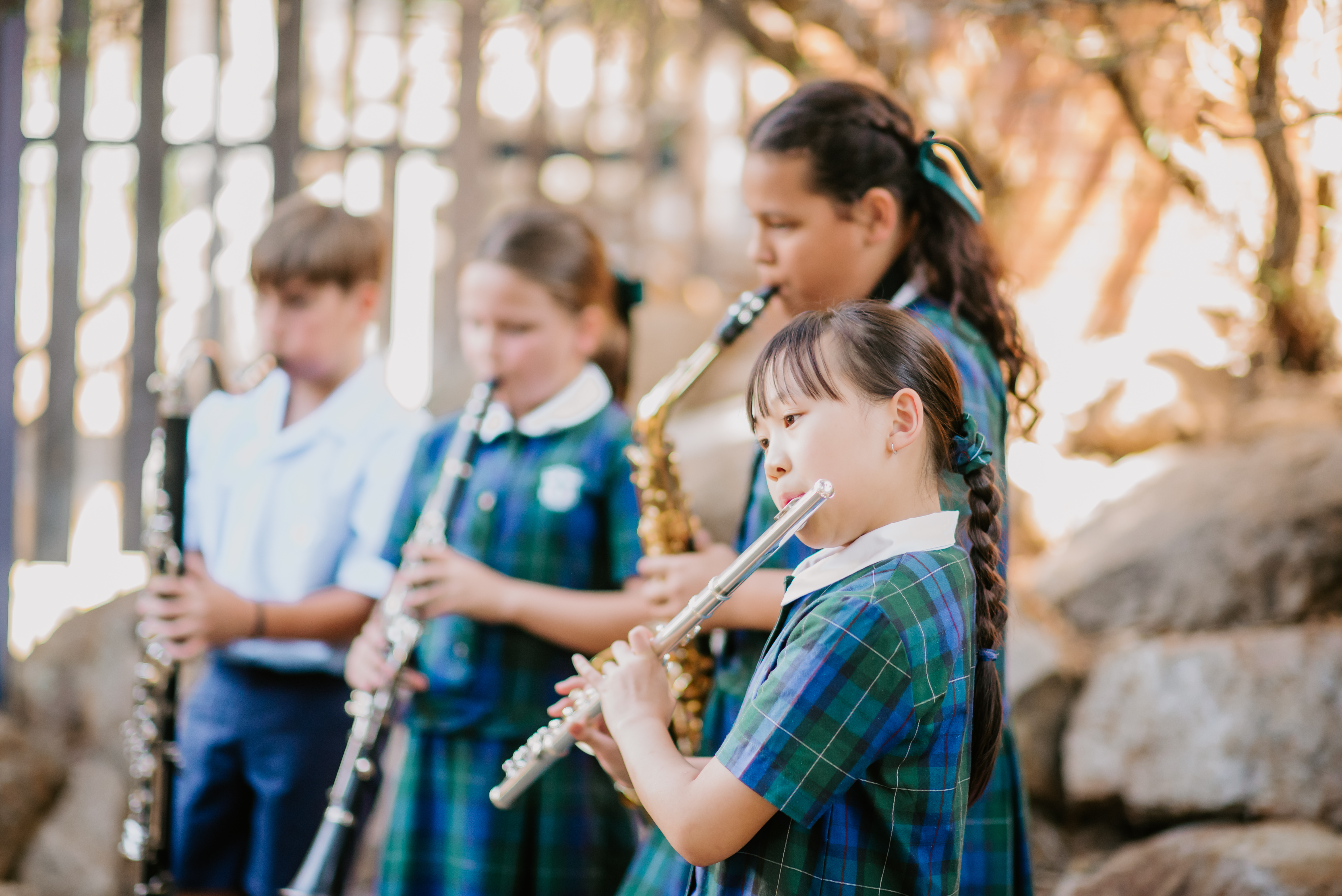 Students playing musical instruments outdoors as part of a school music program.